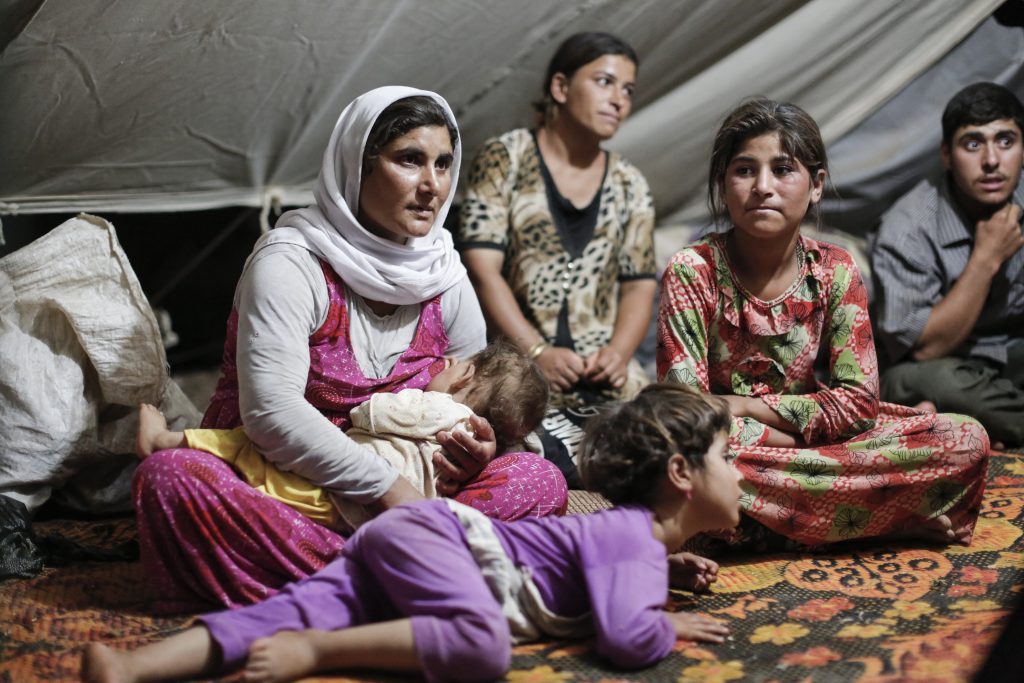 A displaced Yazidi family sit inside their tent in the Nowrouz refugee camp in the town of Derik in Hassock province in Rojave, the autonomous Kurdish region of northern Syria on August 14, 2014.  

The camp, originally set up for displaced Syrians was overwhelmed on August 7 as Iraqi's displaced by the advance of Islamic State fighters fled from the Sinjar region through a safe corridor created by Kurdish fighters. Many of the recent arrival are Yazidis, who were threatened by IS with death if they did not renounce their religion.
[Sam Tarling for The Telegraph]