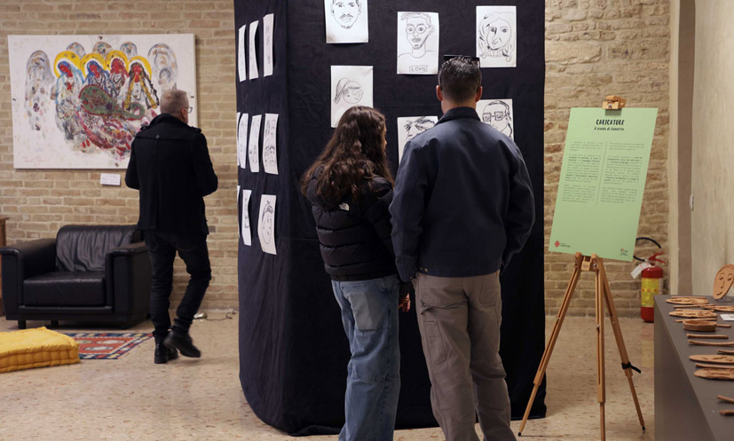 Il pannello della mostra con le caricature dei volti